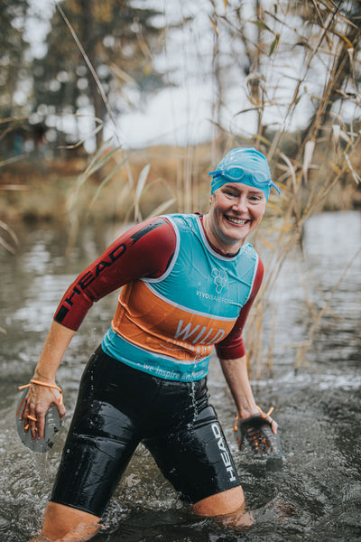 A Swimrunner is smiling at the viewer welcoming them to fill in the Swijin contact form
